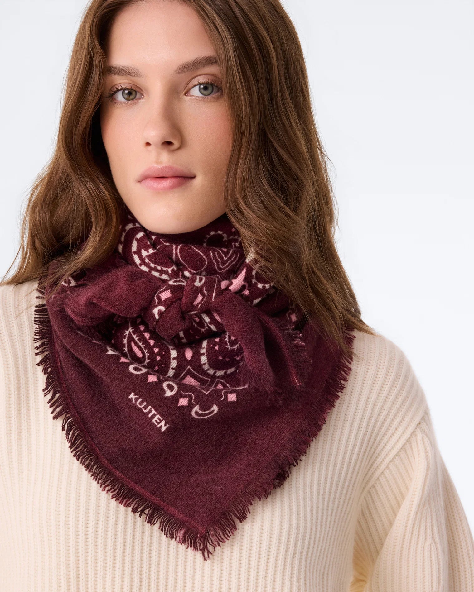 KUJTEN Hachiko Bico scarf in deep red styled over a cream ribbed sweater, modern and cozy look.