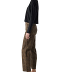 A person stands in profile against a white background wearing the AMO Denim Lillian Plaid Cord pants with a long-sleeve black shirt and black loafers.