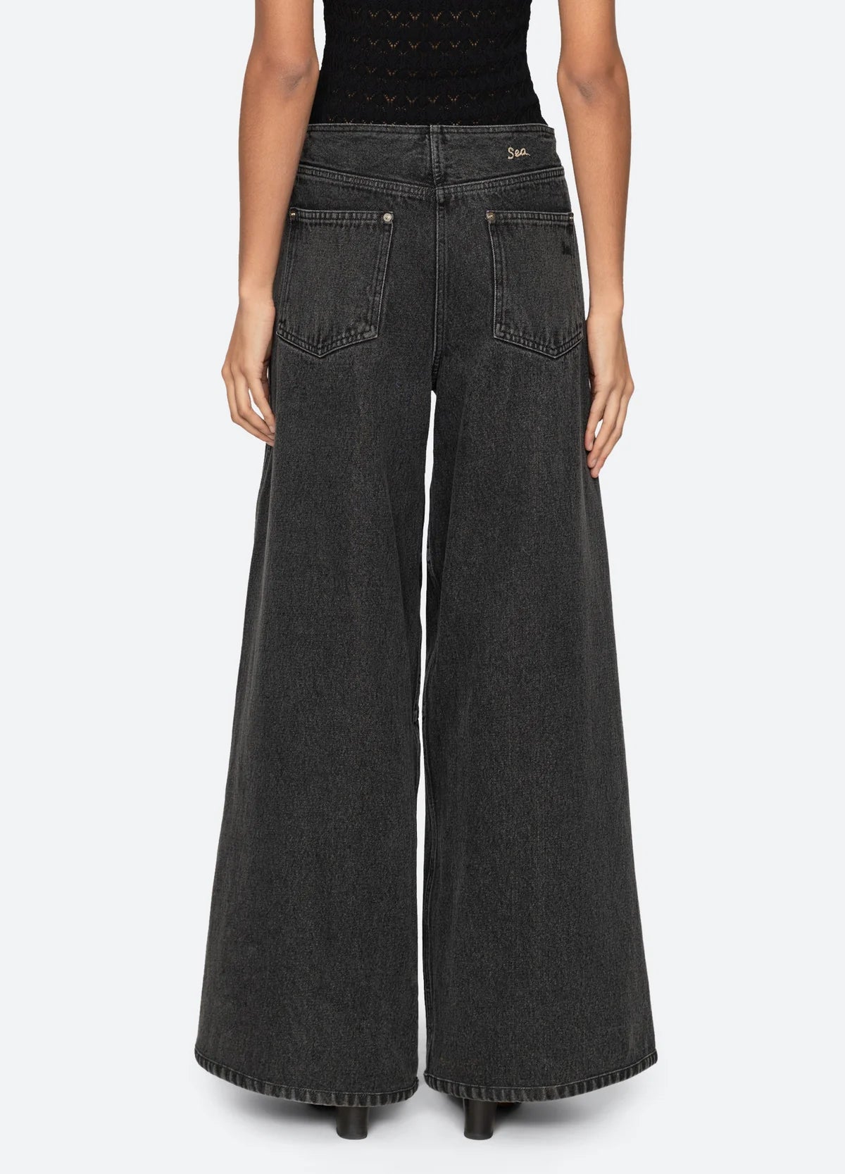 Sea New York Zayna black wide leg denim jeans, shown from the back with a matching black top.