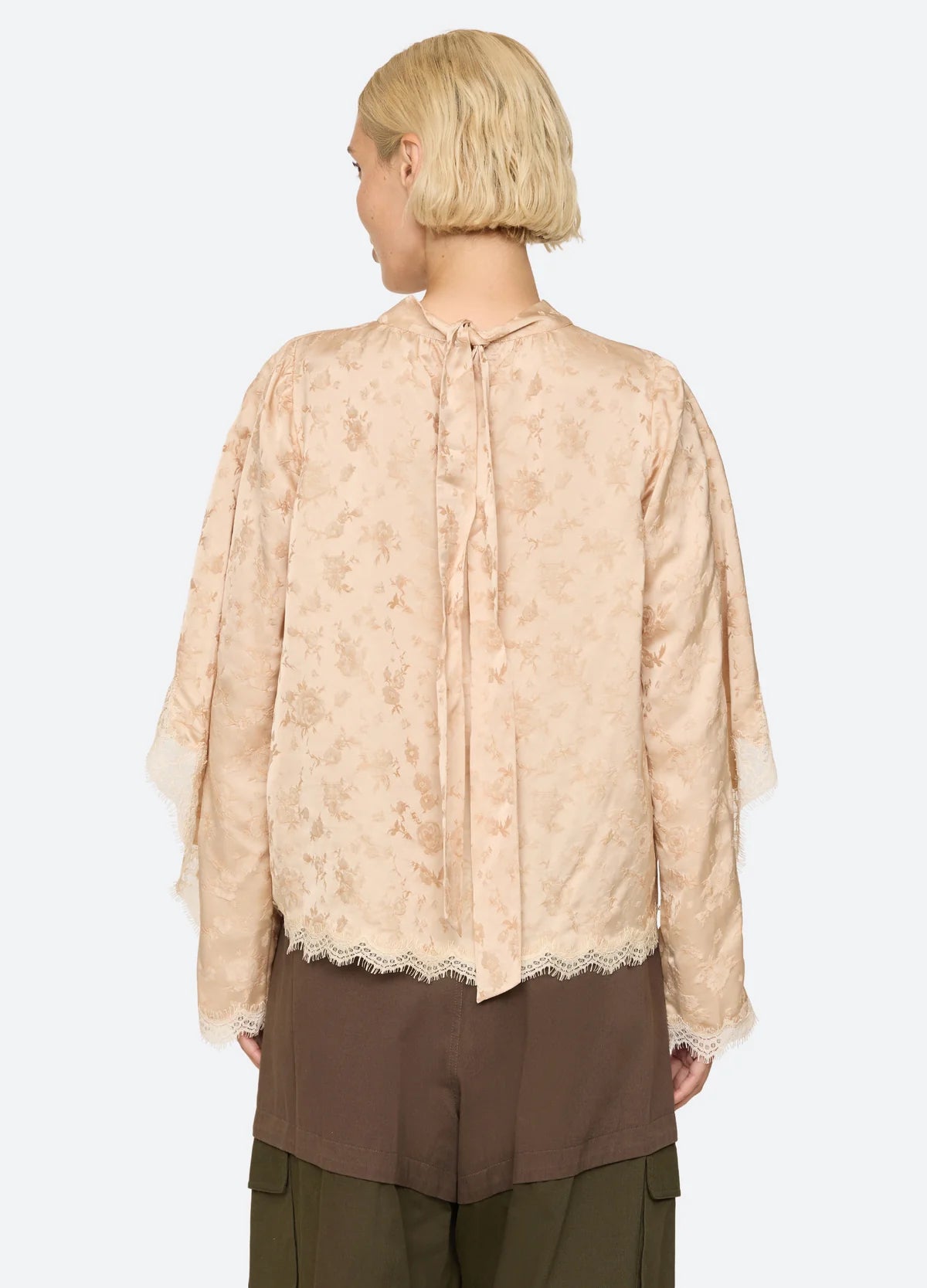 Sea New York Shay Lace LS Top in white lace, shown from the back with brown pants.