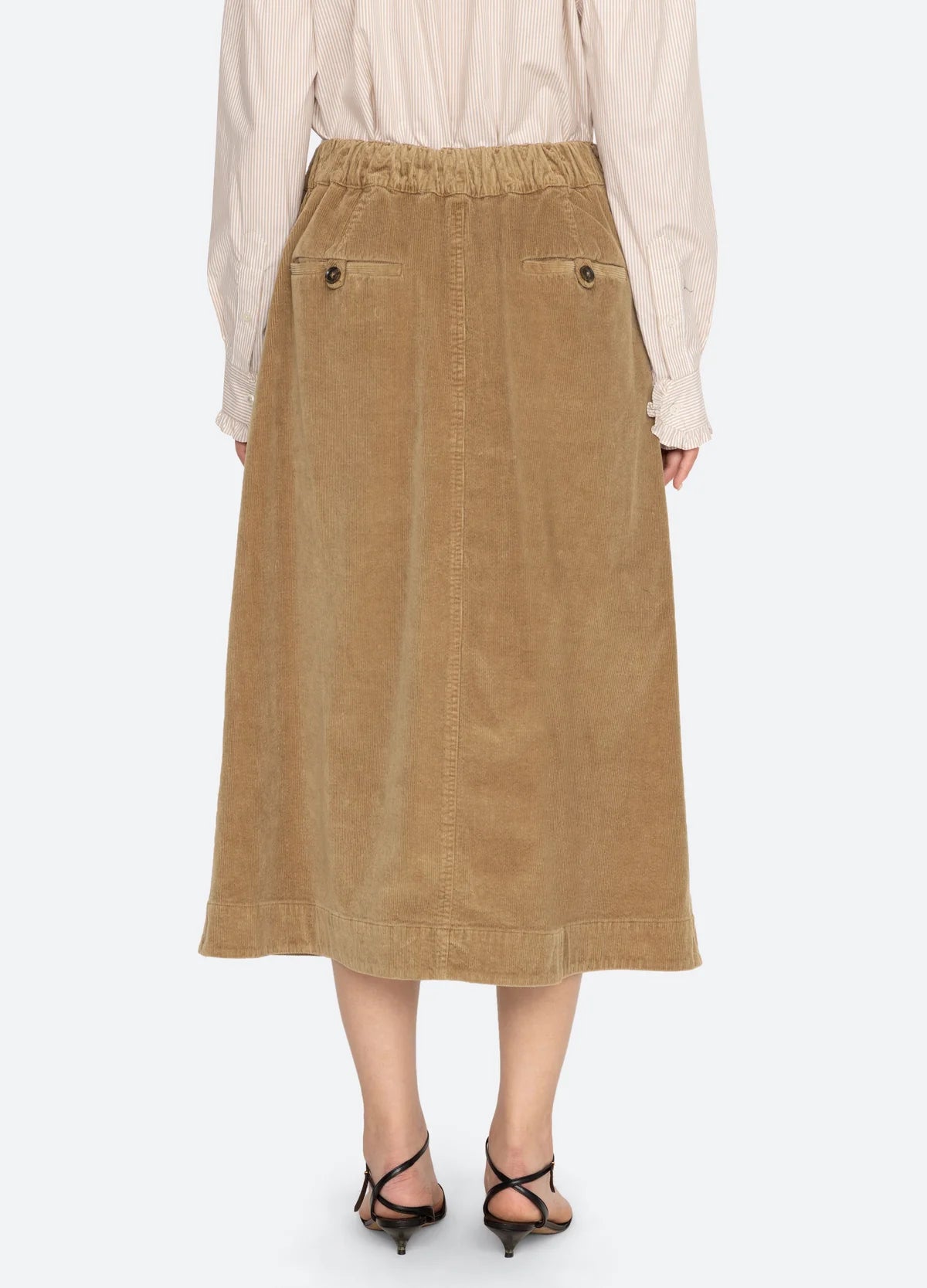 Tan corduroy midi skirt with elastic waist and back pockets by Sea New York, styled with black sandals.