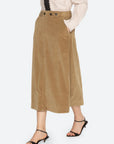 Garrett Corduroy Midi Skirt by Sea New York styled with beige shirt, black tie, and heeled sandals, side view.