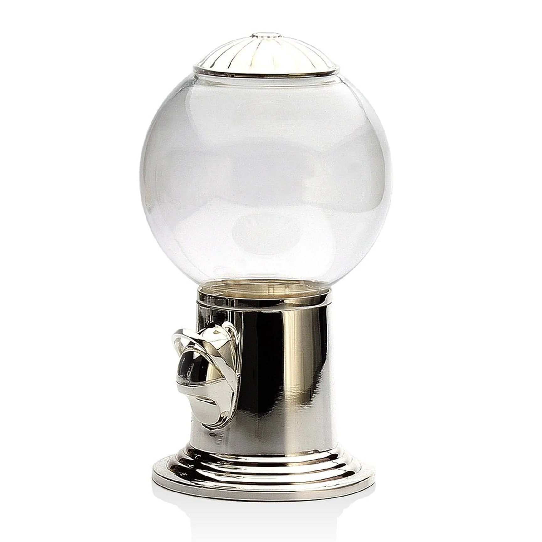 The Godinger (Faire) Candy Machine features a silver metallic base and lid, coupled with a transparent glass globe. The front boasts a coin slot and turn knob. This elegant candy dispenser, showcasing a timeless design, is displayed on a reflective white surface with no contents inside.