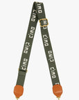 Clare Vivier's Crossbody Strap S25 features green adjustable cotton webbing, gold hardware, and brown leather accents. "Ciao" is repeatedly woven in white—ideal for elevating any favorite crossbody or shoulder bag.