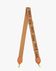 The Clare Vivier Adjustable Crossbody Strap is a tan cotton webbing strap with gold clasps at each end and bold, repeated "ciao" text in black.