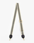 The Clare Vivier Crossbody Strap S25 is a black and white checkered cotton webbing strap with gold clips and black leather ends, adjustable for a crossbody or shoulder bag, shown on a white background.