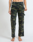 A person stands barefoot against a plain background, wearing the relaxed-fit Carpenter pants from ASKK. These camo cargo pants, crafted from stretch twill, feature practical side pockets and offer a comfortable fit. They are proudly made in Los Angeles. The person's upper body is not visible.