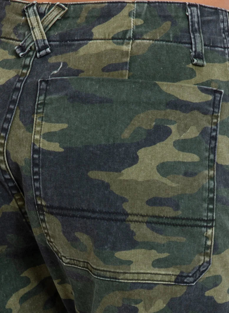 Close-up view of the back pocket from ASKK's Carpenter pants, crafted in Los Angeles with a green and brown camouflage pattern. The fabric showcases stitched and textured details, emphasizing its classic military-style design.