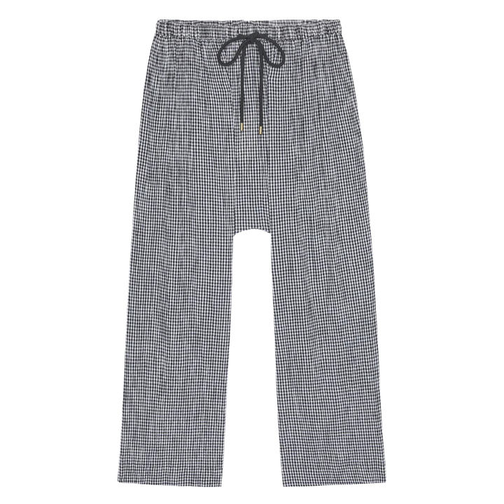 The Reef Pant by The Great Inc.—black and white gingham check, relaxed fit with wide straight legs, elastic waistband, and black drawstring—shown laid flat on a white background.