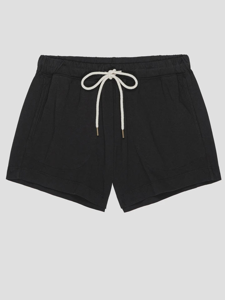 The Great Inc. presents The Flutter Short: black cotton shorts with an elastic waistband, white drawstring, two front pockets, and a relaxed fit. Made in Los Angeles, shown on a plain light gray background.