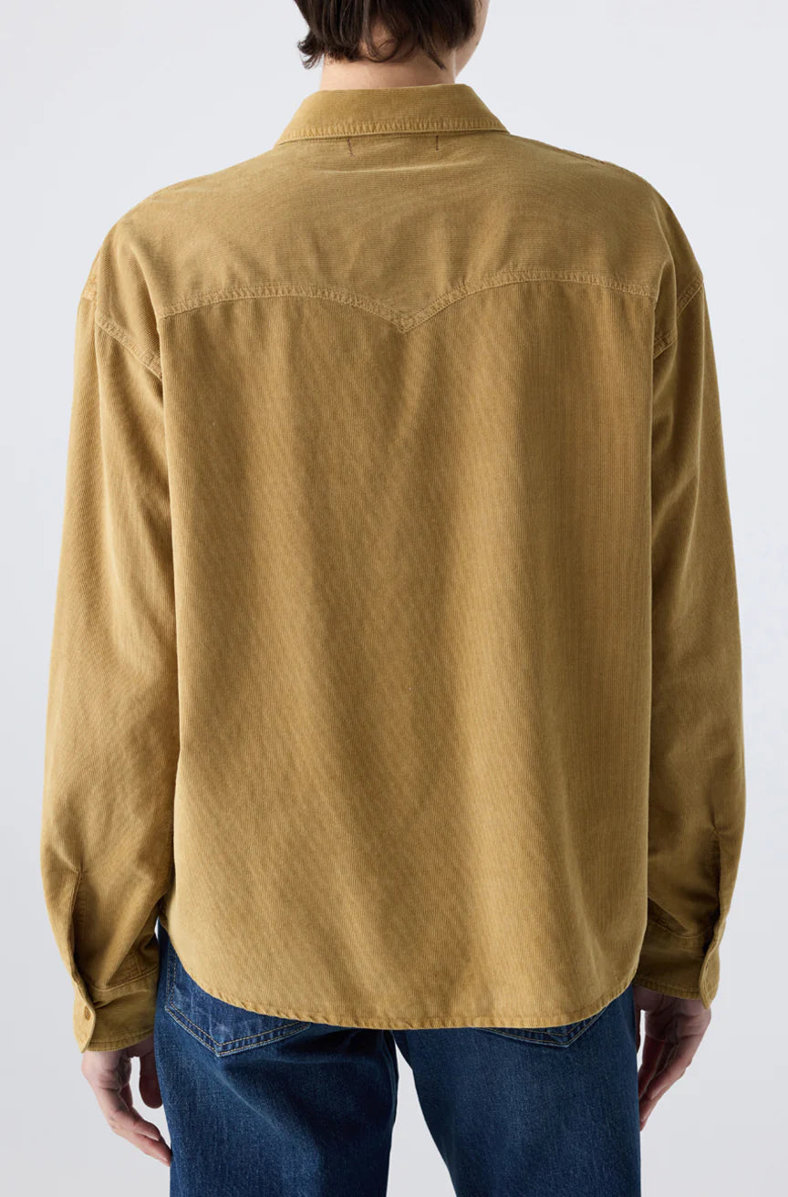 A person shown from the back wears the AMO Denim Jenn Shirt in light brown corduroy with blue jeans, set against a plain, light background.