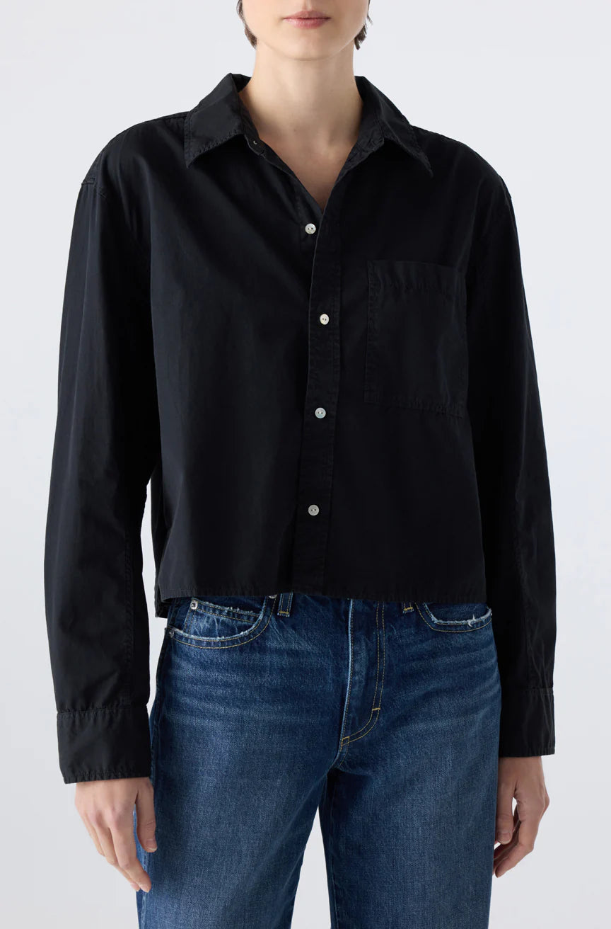 A person wearing the Ruth Crop Shirt by AMO Denim, an oversized black cotton poplin shirt.