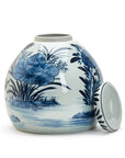 The Blue White Ginger Jar by Two's Company is a round porcelain jar featuring blue floral and water scene designs, shown on a white background with its matching lid placed beside it.
