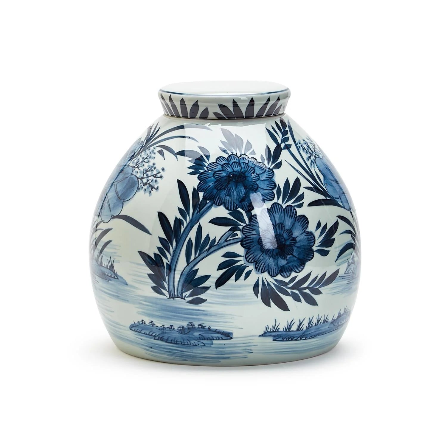 The Blue White Ginger Jar by Two's Company is a round, white porcelain jar with a short neck, featuring traditional blue floral and leaf designs.