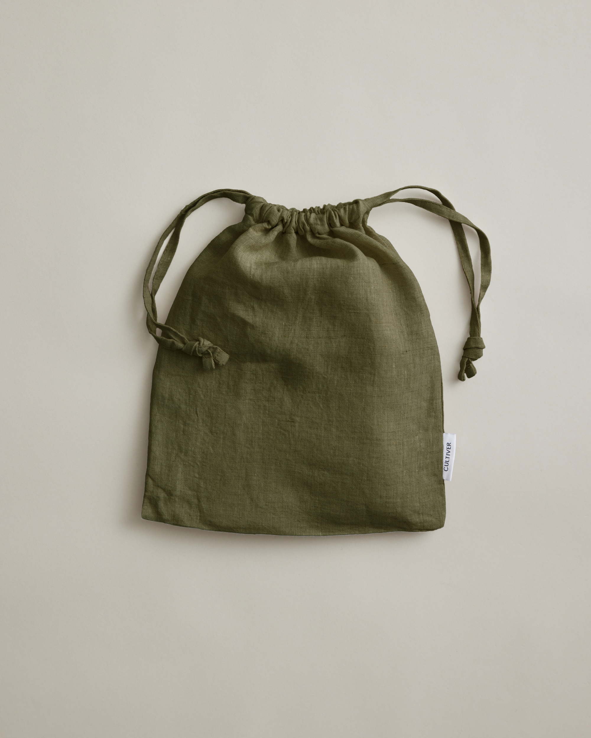 Olive green linen pillowcases by Cultiver Goods, set of 2, displayed on a light beige background.