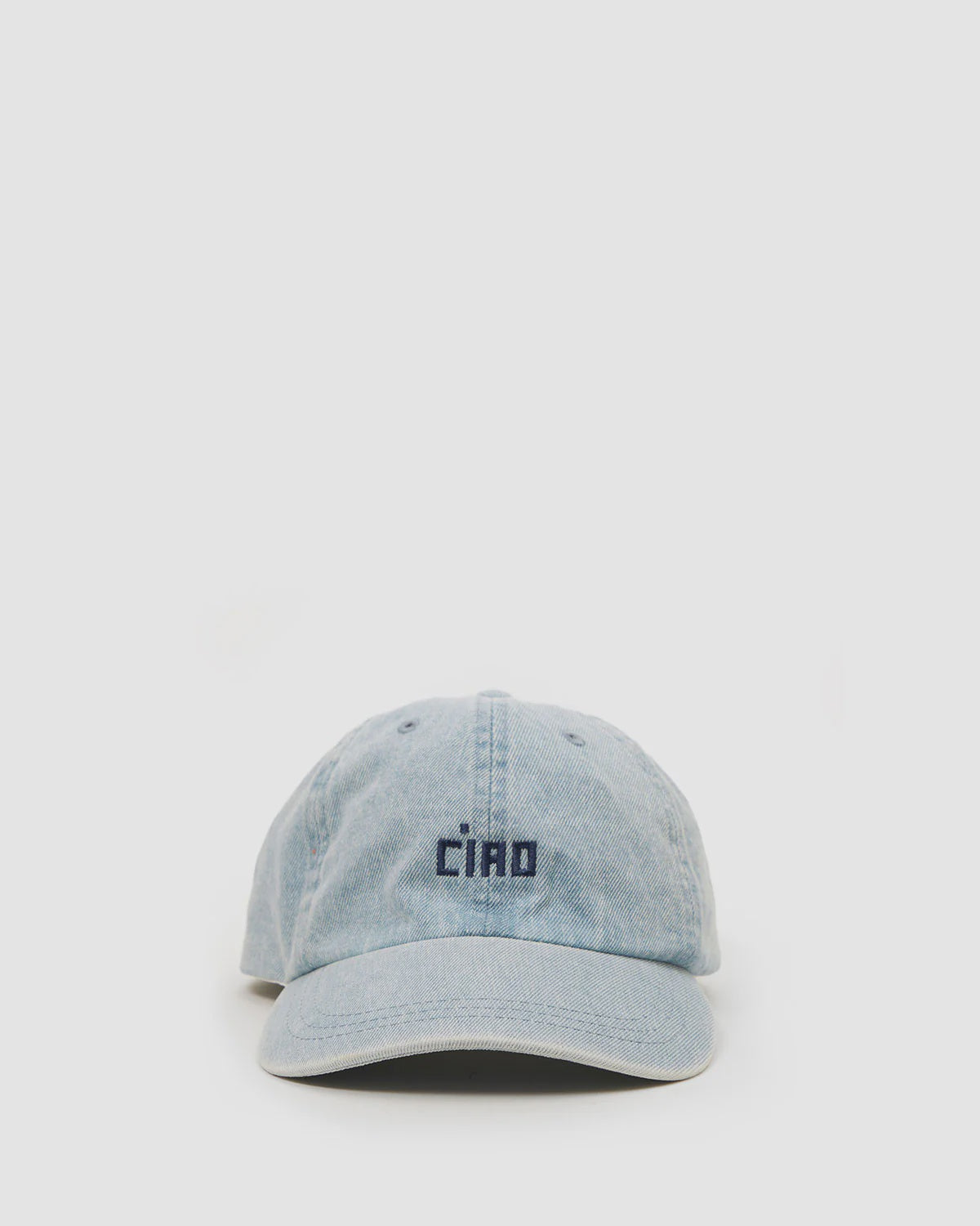 The Clare Vivier Baseball Hat is a light blue denim embroidered cap featuring "CIAO" in black on the front, perfect for a celebrity in disguise, and displayed against a plain white background.