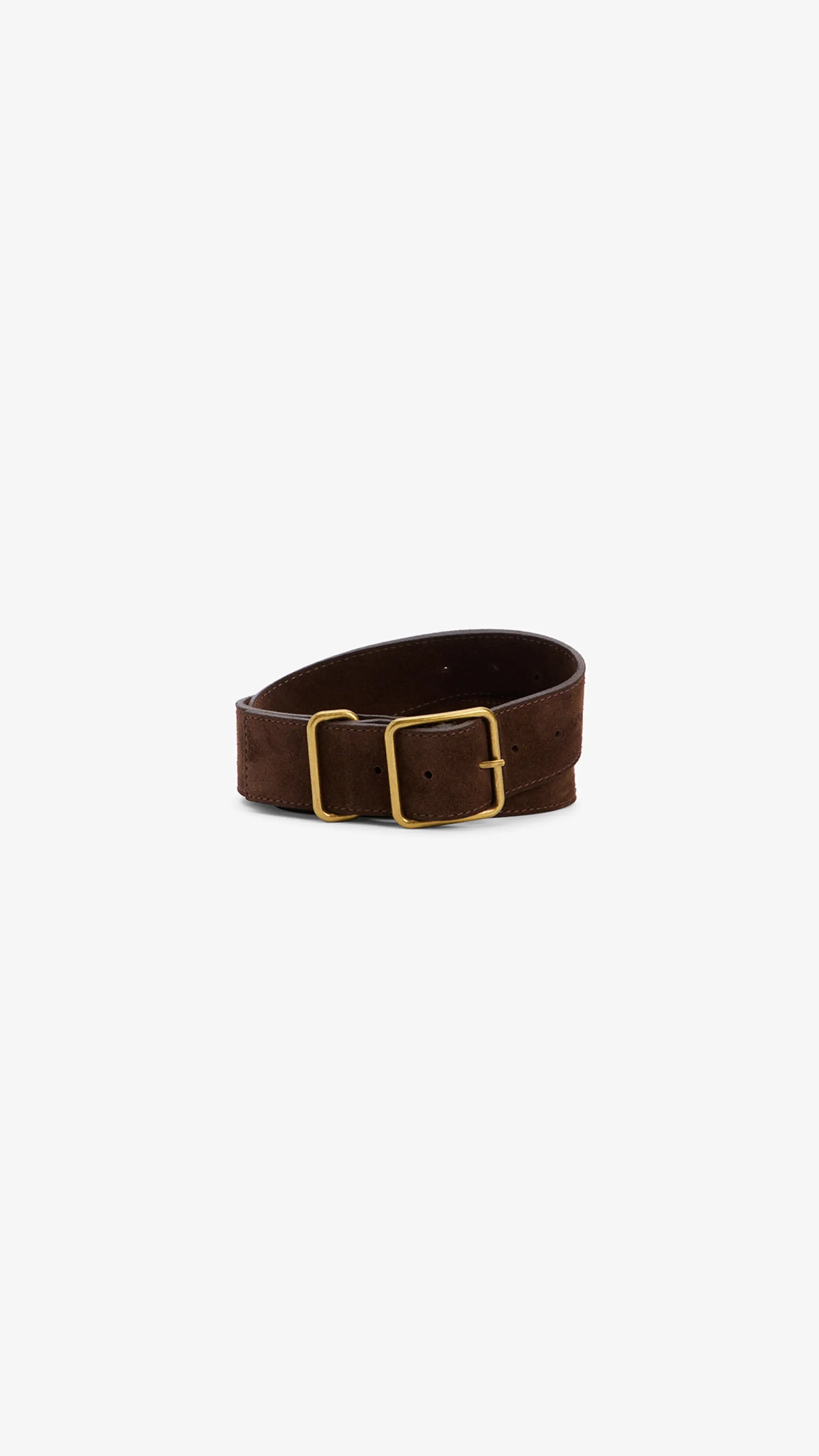 The Janessa Leone Bowe Belt, made from dark brown Italian suede with a rectangular gold custom hardware buckle, is shown coiled in a loose roll on a plain white background.