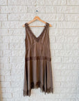Lace-trimmed brown cupro viscose slip dress by Xirena on hanger against white brick wall at Bungalow Furniture & Accessories.