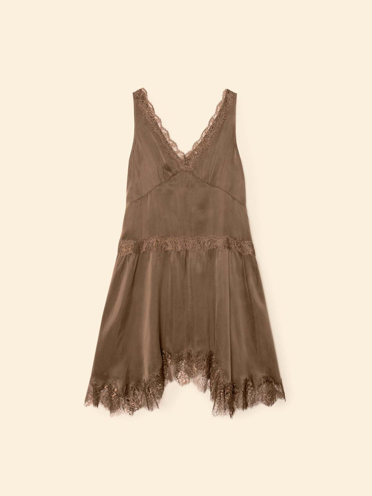 Brown satin slip dress with lace neckline and handkerchief hem by Xirena, shown on a beige background.