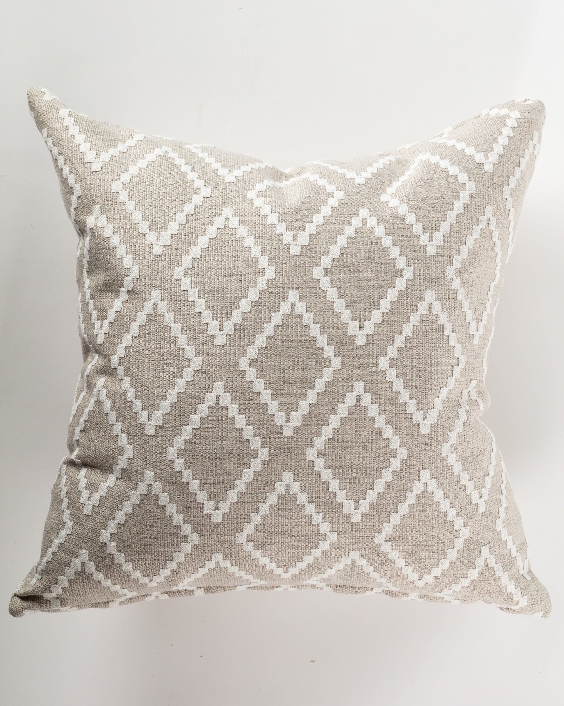 The 26x26" Iconic Linen Pillow by Gabby showcases a beige background with a white geometric diamond pattern, offering ideal support and layering. This ultra-luxurious euro pillow enhances any space with its sophisticated design.