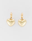 A pair of Bubble Heart Earrings by Lucky Star with a smooth, polished finish. Each heart is attached to elegant gold hoop clasps, creating a simple yet sophisticated design. The jewelry is displayed against a plain white background.