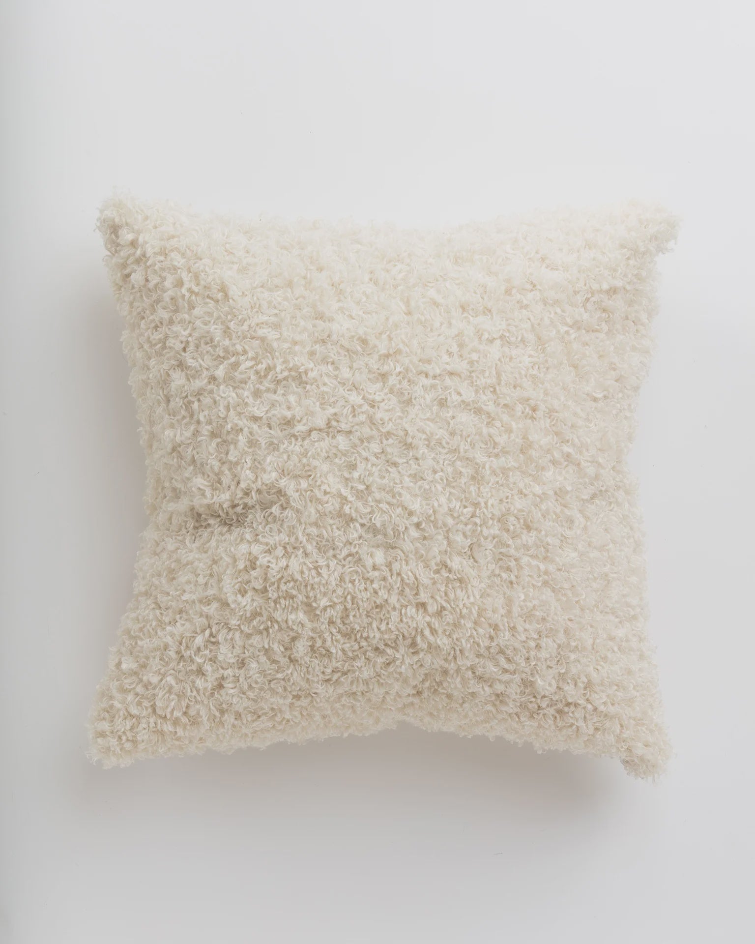 A Gabby Curly Ivory Pillow 26x26 with a textured surface on a plain white background, perfect for a cozy bungalow in Scottsdale, Arizona.
