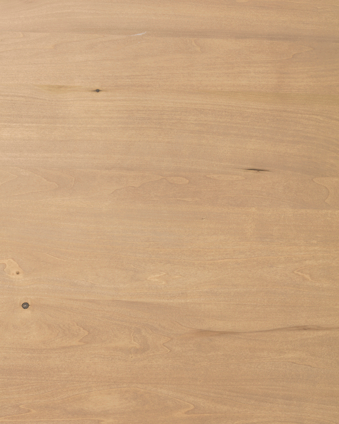 A smooth, close-up view of a light brown wooden surface with subtle grain patterns and a few small dark spots. The wood texture appears even and natural, embodying the warm, earthy tones commonly found in Scottsdale bungalows.