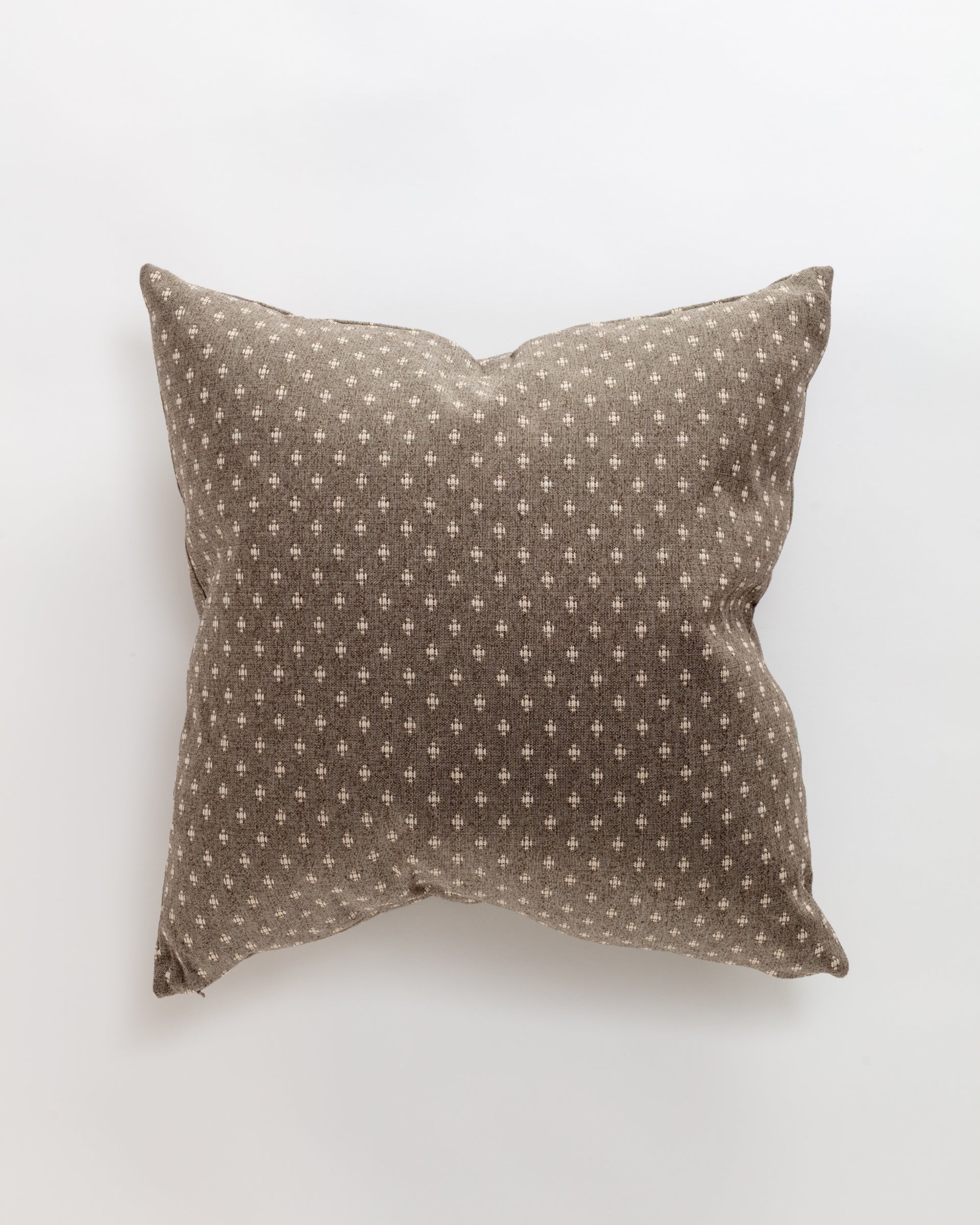 The Colonial Pillow by Norwalk is a square throw pillow with a brown fabric cover adorned with small white plus sign motifs on a plain white background, offering luxurious comfort.