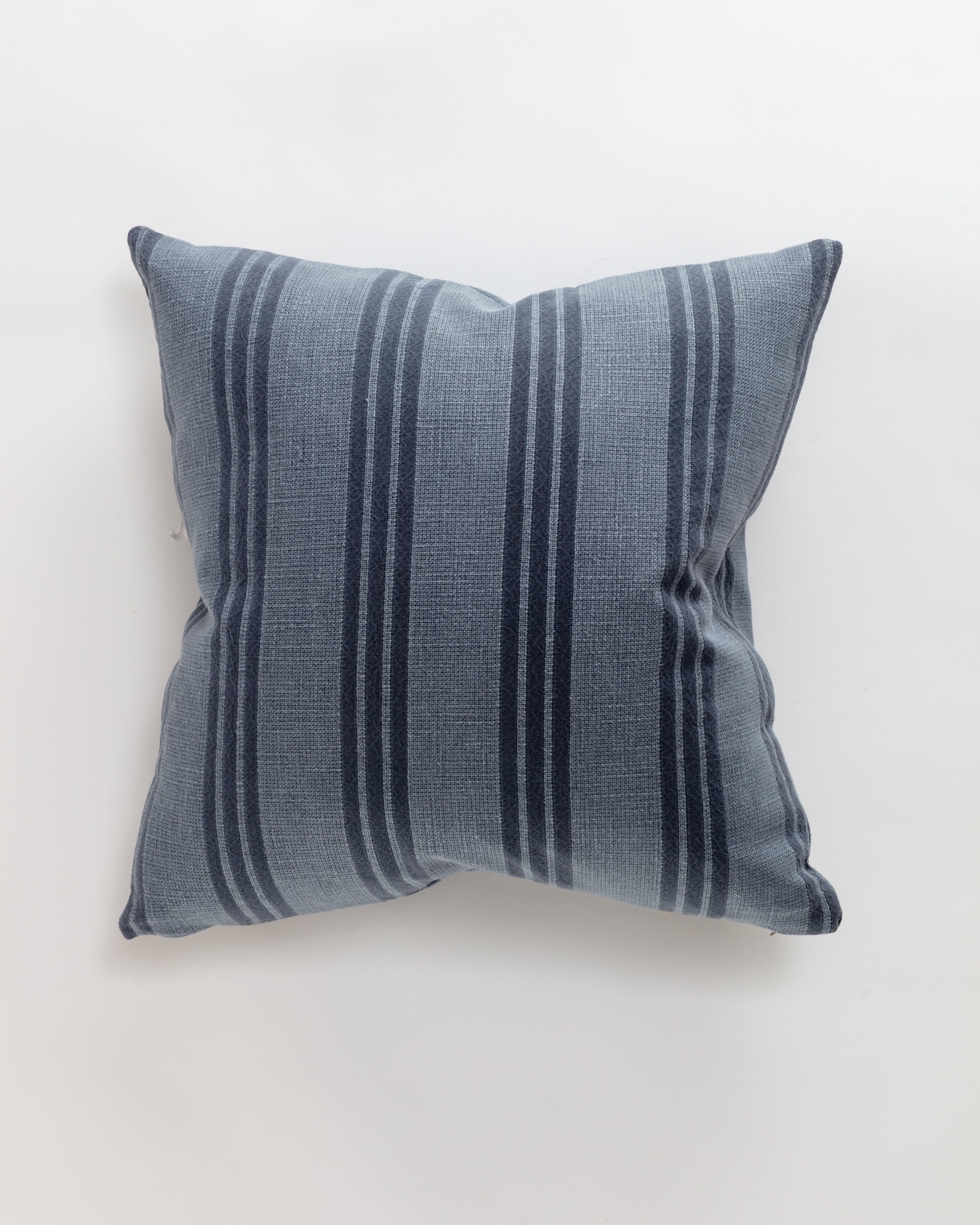 The Thrive Pillow by Norwalk, featuring a light blue fabric with dark blue vertical stripes, rests on a plain white background, offering an ultra-luxurious finish.