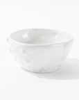 Bowl No. 130 from Montes Doggett, a handmade ceramic piece with a textured surface marked by dimple-like indentations, is centrally placed against a plain white background. Crafted using traditional techniques, this bowl boasts a glossy finish and embodies a minimalist, modern design.