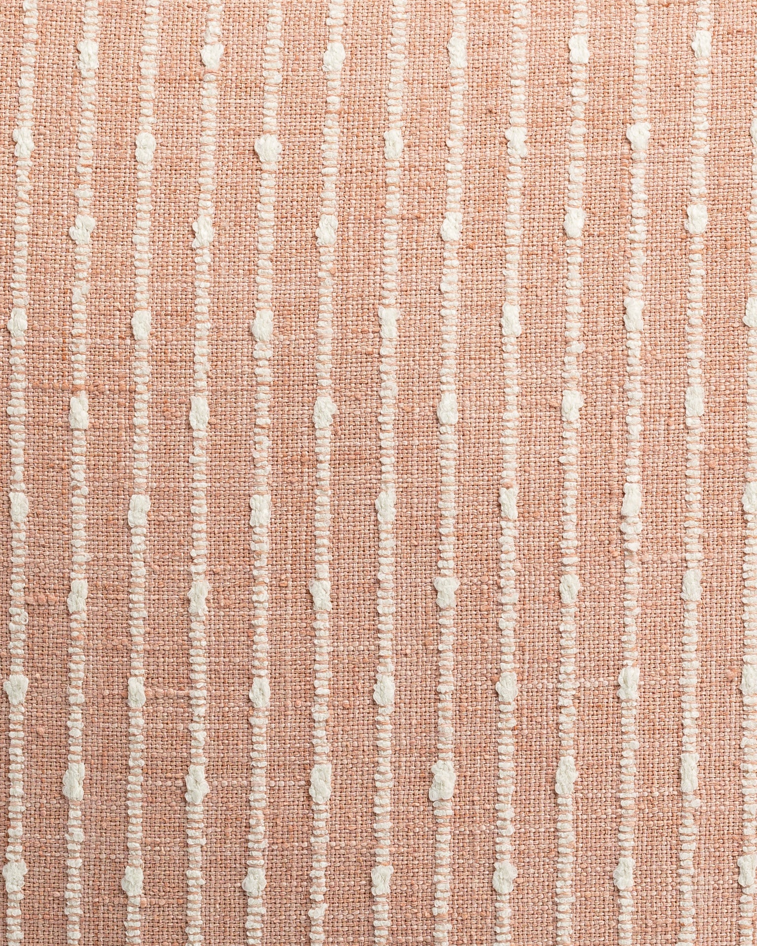 Close-up of a textured fabric with parallel peach-colored stripes and intermittent white tufts, creating a tactile and visually interesting pattern in Gabby's Hopscotch Blush 26x26 style.