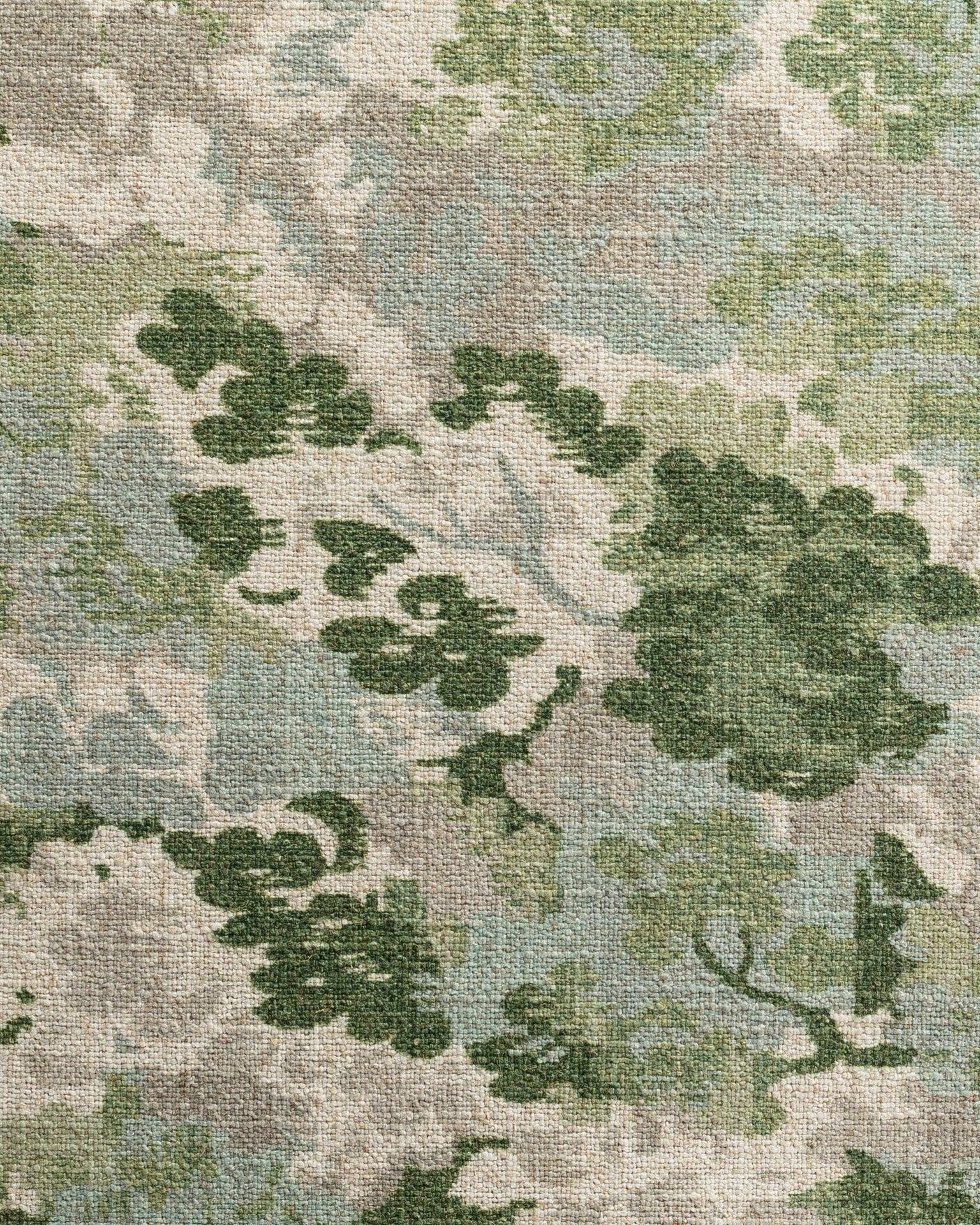 A close-up image of an Imperial Ivy Pillow 26x26 by Gabby, with a floral pattern featuring various shades of green leaves on a textured bungalow-style beige background.