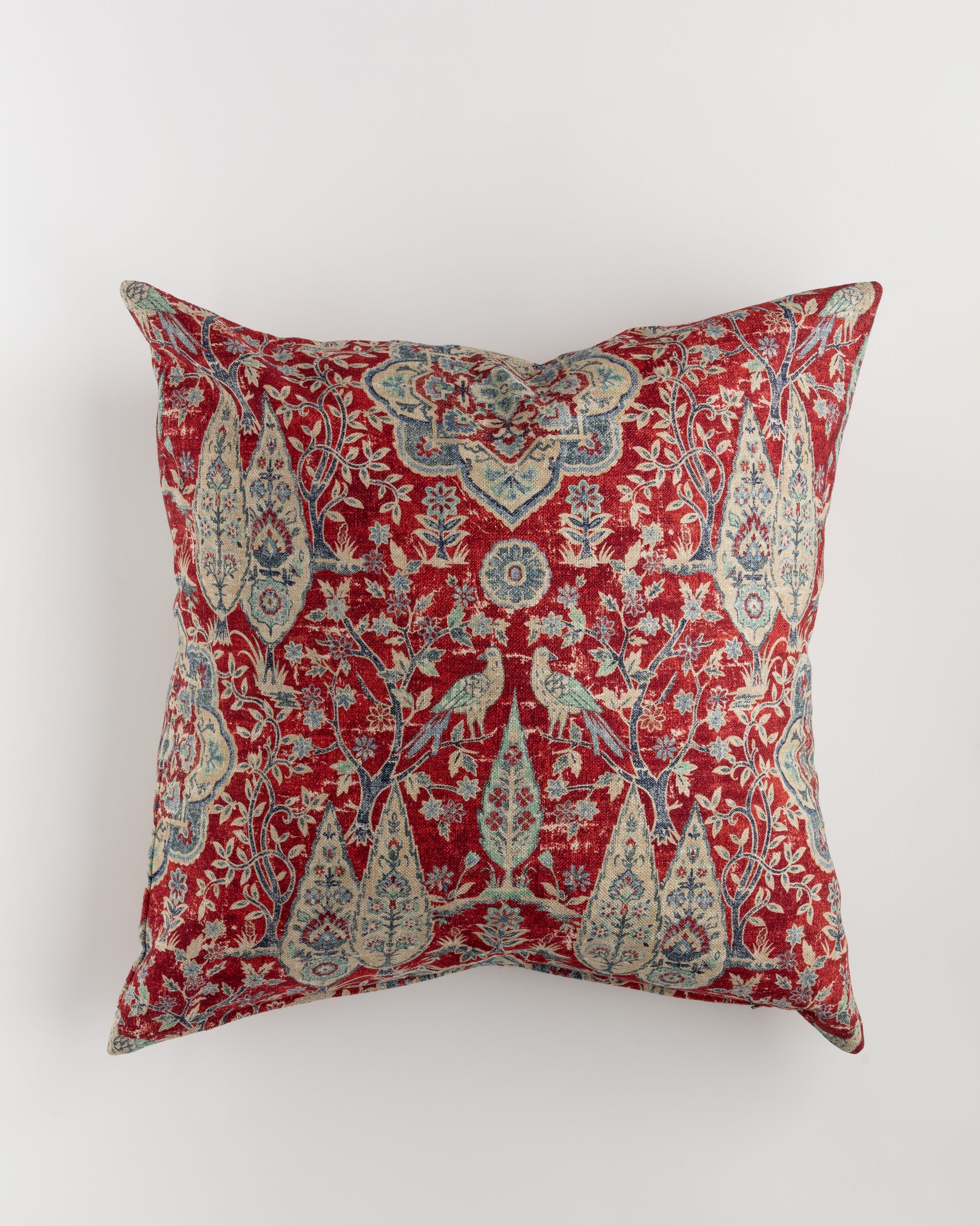 The Custom 1 Pillow 28x28 by Pindler is a luxurious decorative square pillow with a red background, showcasing an intricate pattern of birds, flowers, and leaf motifs in blue, beige, and green. This traditional design, reminiscent of Persian or oriental art, perfectly complements Euro pillows or your favorite pillow insert.