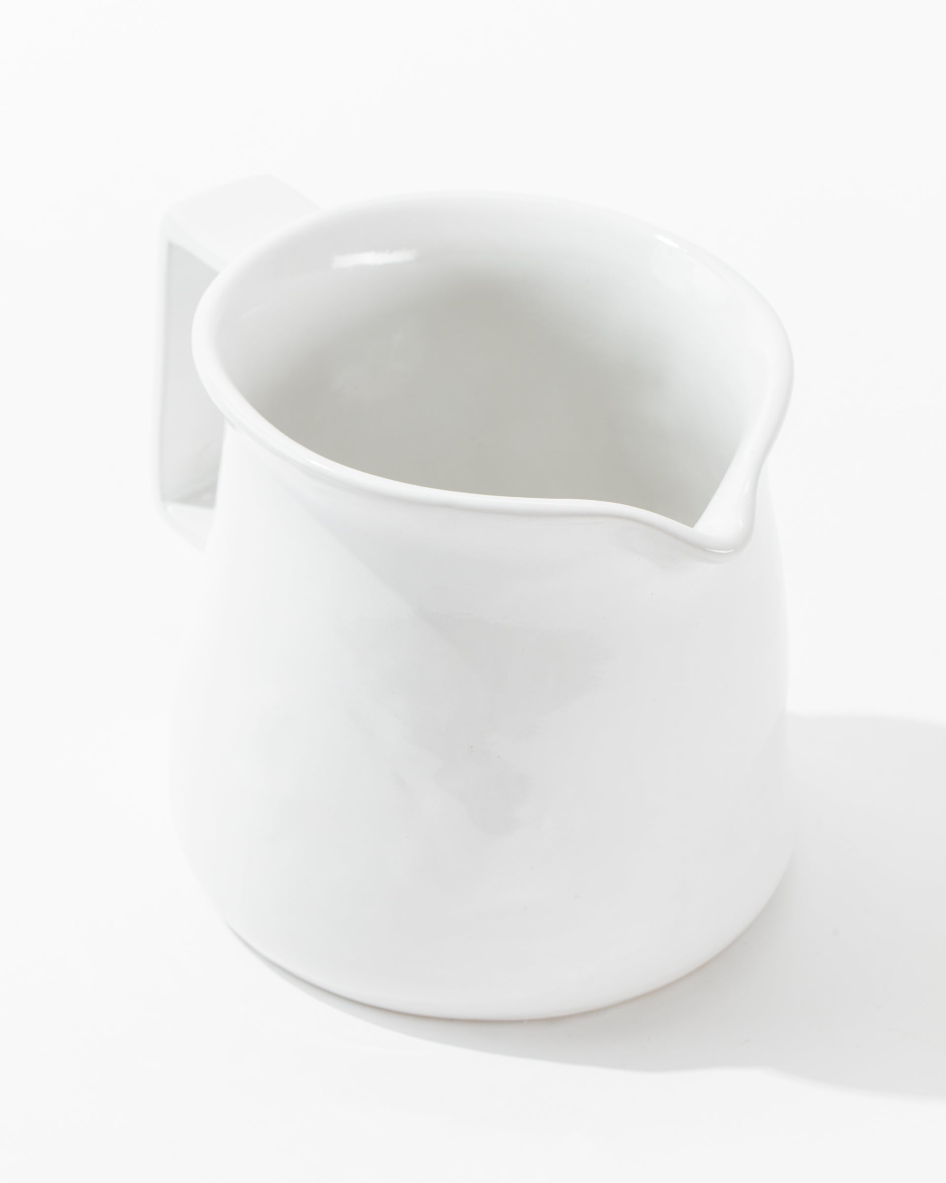 Pitcher No. 750 by Montes Doggett is a handmade ceramic pitcher featuring a spout and handle, showcased against a plain white background. It boasts a high-fired construction with a simple, smooth design and a slightly glossy finish.
