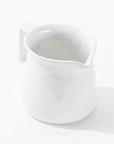 Pitcher No. 750 by Montes Doggett is a handmade ceramic pitcher featuring a spout and handle, showcased against a plain white background. It boasts a high-fired construction with a simple, smooth design and a slightly glossy finish.
