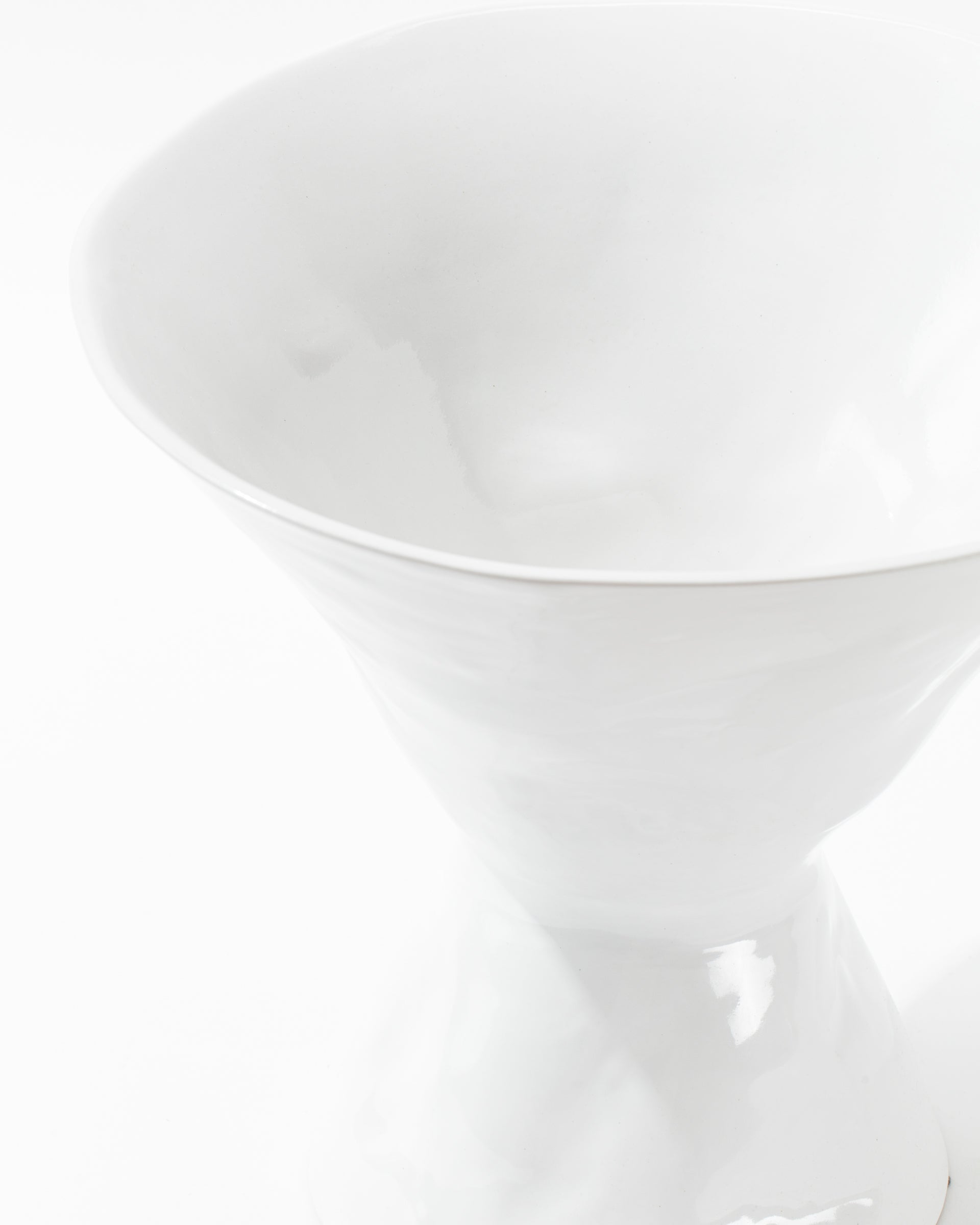 A close-up view of the sophisticated Catchall Bowl No. 979 by Montes Doggett, showcasing its elegant white ceramic design with a smooth and glossy surface that reflects light softly against a white background.