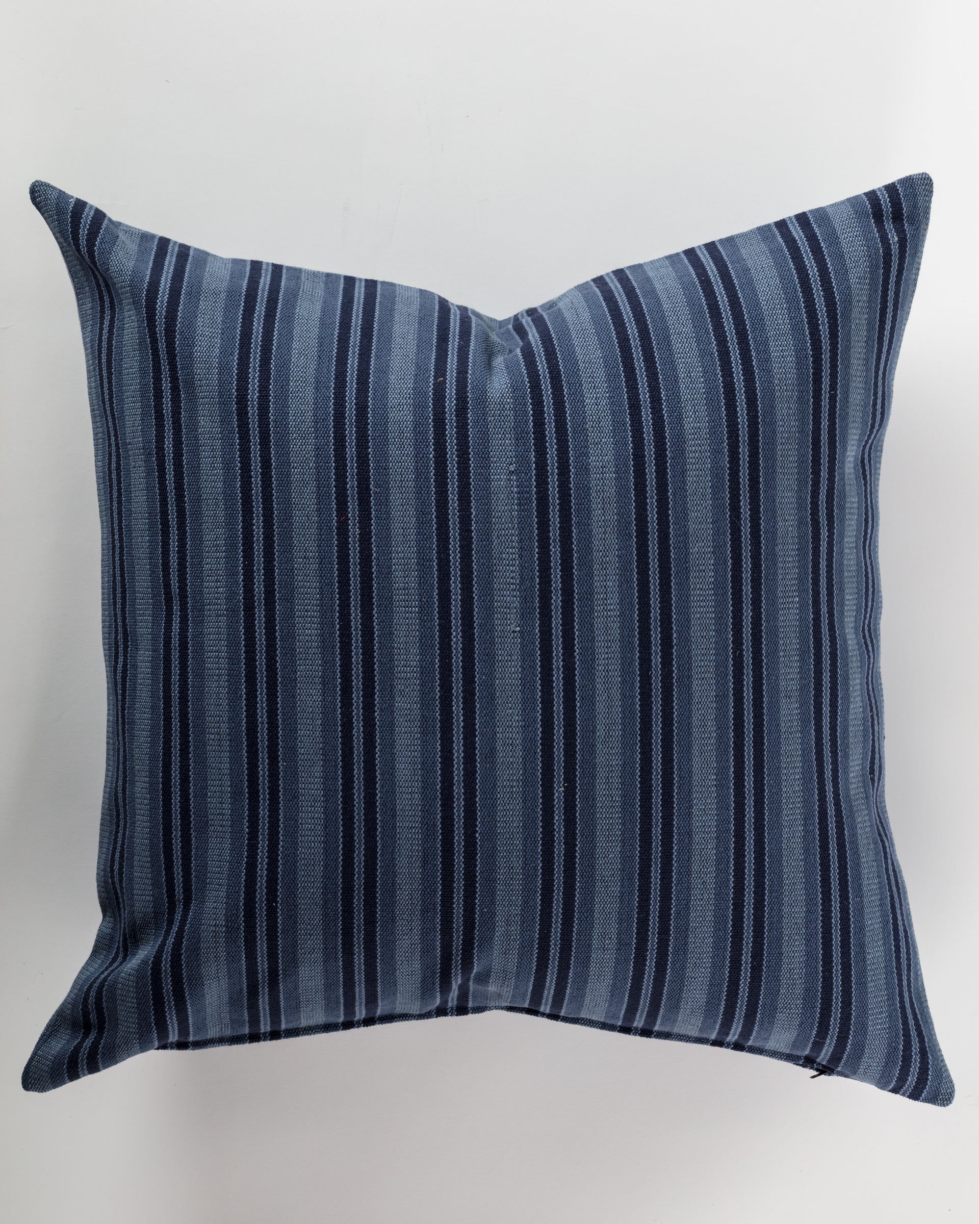 The Custom 3 Pillow 28x28 by Pindler provides both comfort and support with its luxurious design featuring dark blue and light blue vertical stripes on a white background. Its symmetrical pattern and soft, woven texture contribute to an elegant appeal.