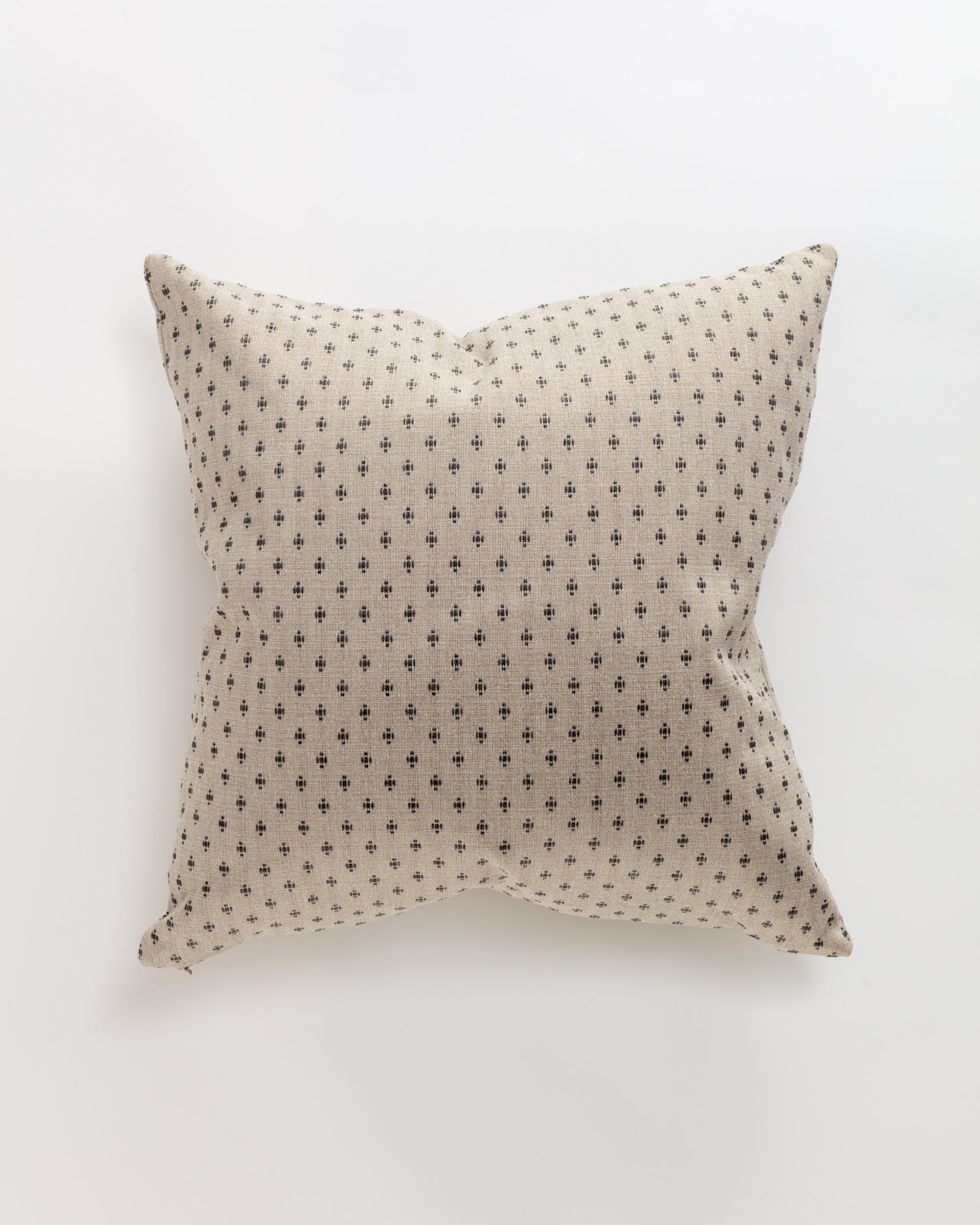 The Colonial Pillow by Norwalk is a custom-made beige square cushion with a subtle pattern of small, dark crosses. It offers soft texture and support, making it an ultra-luxurious accent on a plain white background.