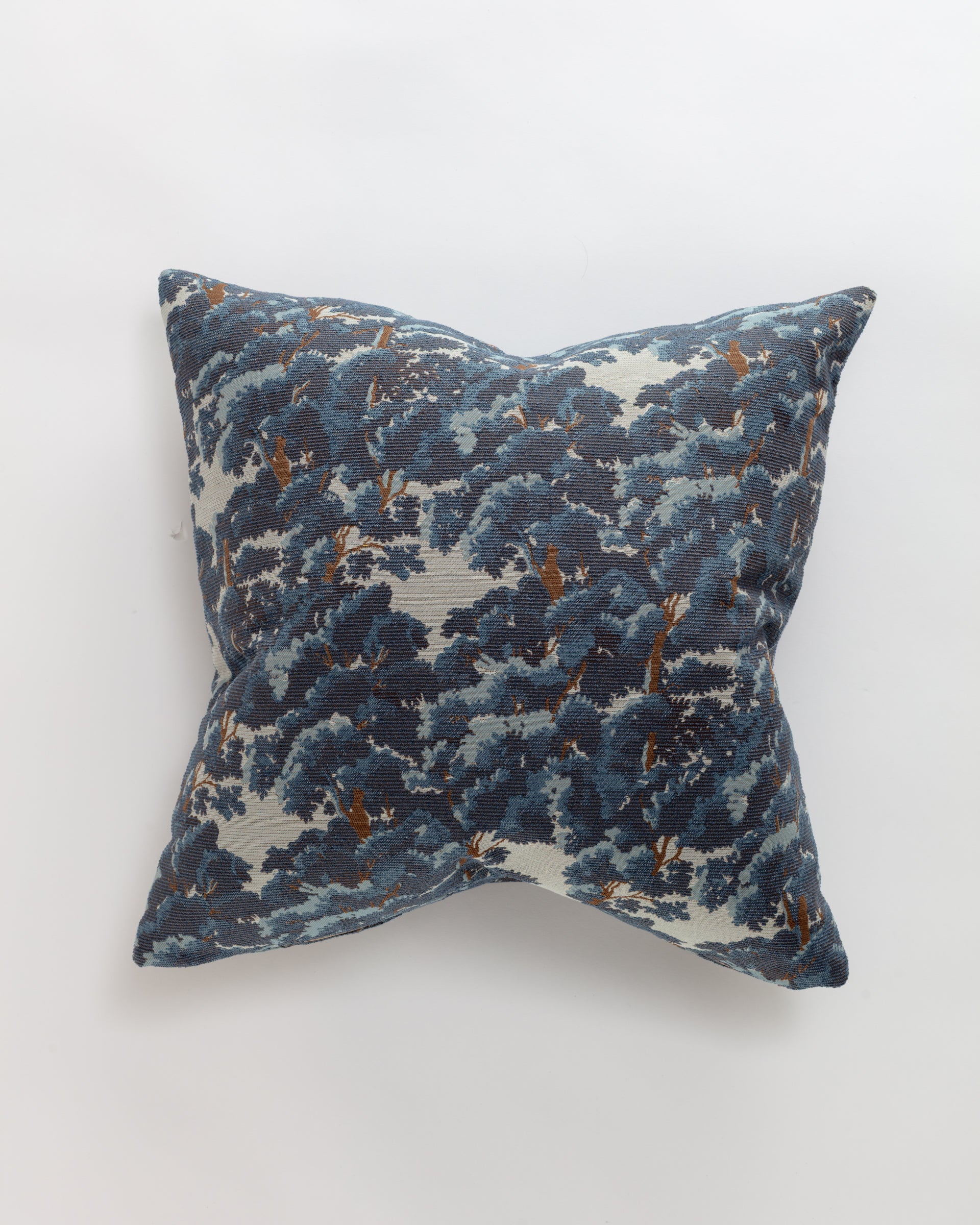 The North Oak Pillow by Norwalk is a luxurious euro pillow featuring a blue and white floral pattern with dark blue and brown leaves on a white background, ideal for placement against light surfaces.