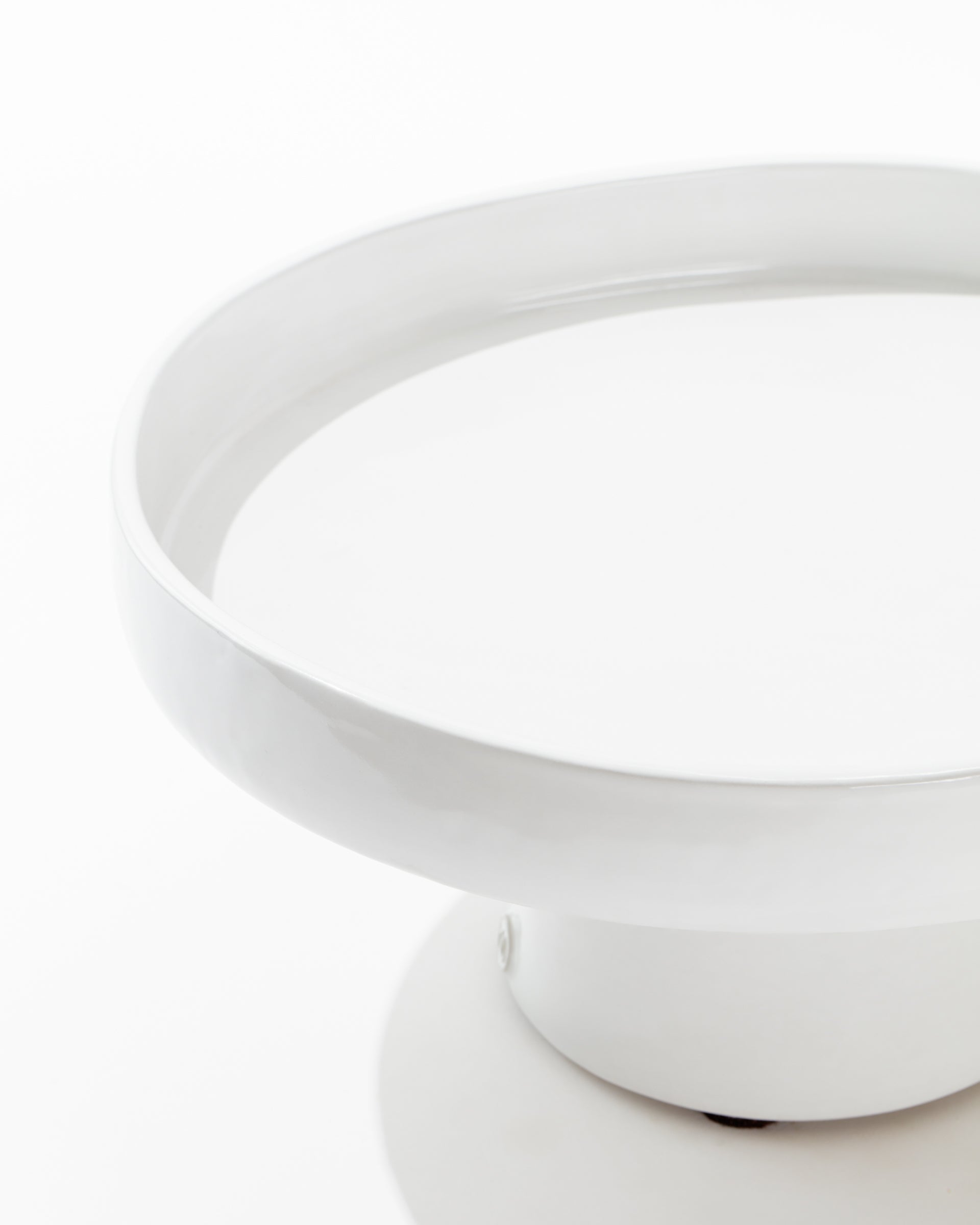 A close-up of the Montes Doggett 4807-L Cake Stand no. 807 L, showcasing its modern, round, white high-fired ceramic design with a wide, shallow structure and a small base. The cake stand features clean lines and a glossy finish, set against a plain white background.