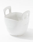 The 4994 Bowl no. 994 by Montes Doggett is a white ceramic container with a smooth finish, featuring two large handle openings on opposite sides near the top. Handmade in Peru, this high-fired ceramic piece has a broad, rounded base and tapers slightly toward the top, giving it a modern, minimalist design.