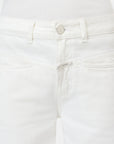 Close-up of a person wearing CLOSED Tori X Denim mid-rise white jeans, crafted from recycled cotton with a silver button, front pockets, subtle stitching, and a tucked-in white ribbed top.