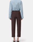 Souki light blue button-up shirt and cropped wool trousers by CLOSED, styled with black heels, back view.