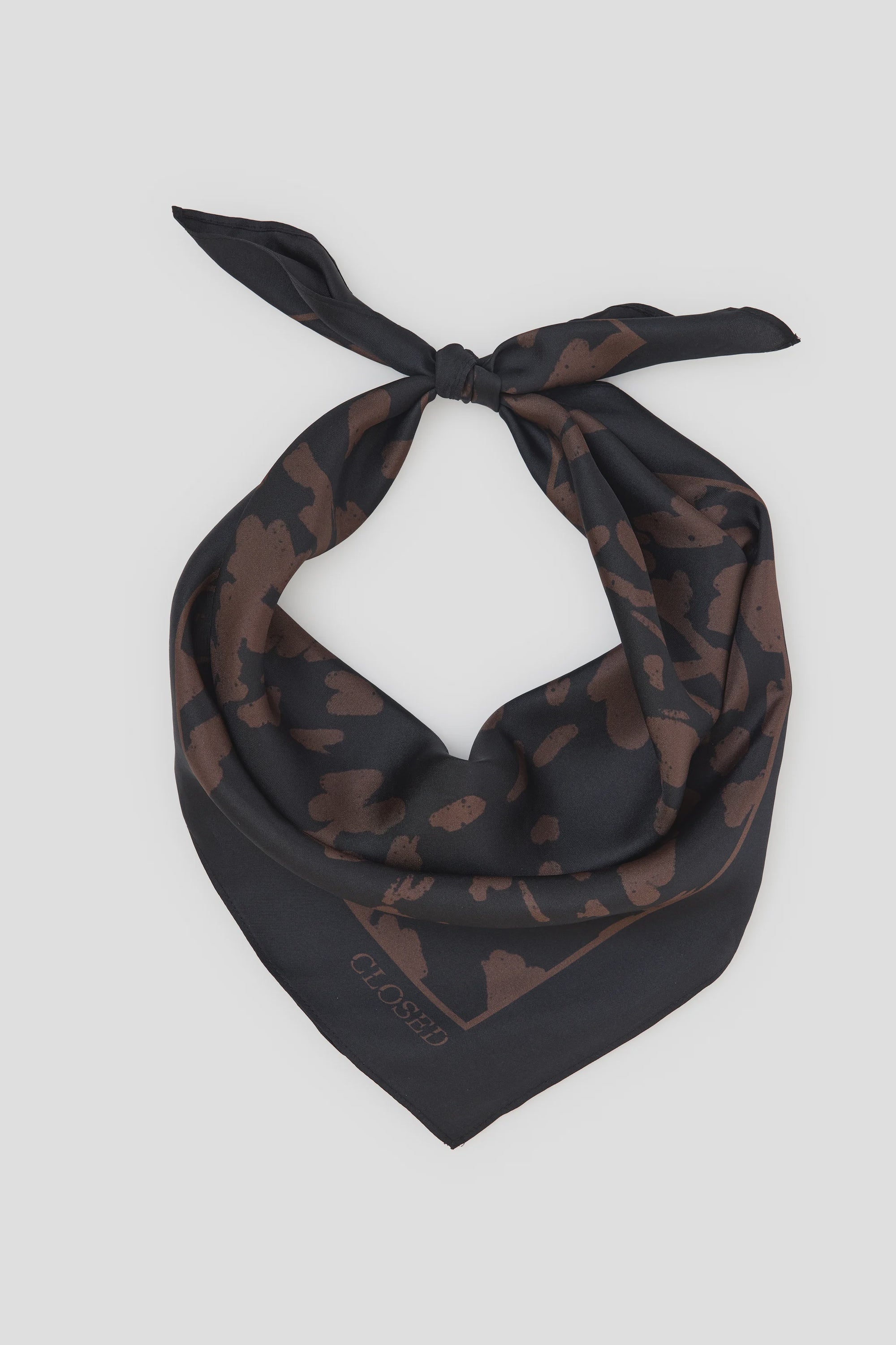 Black silk square scarf with brown animal print, logo in corner, CLOSED accessory on white background.