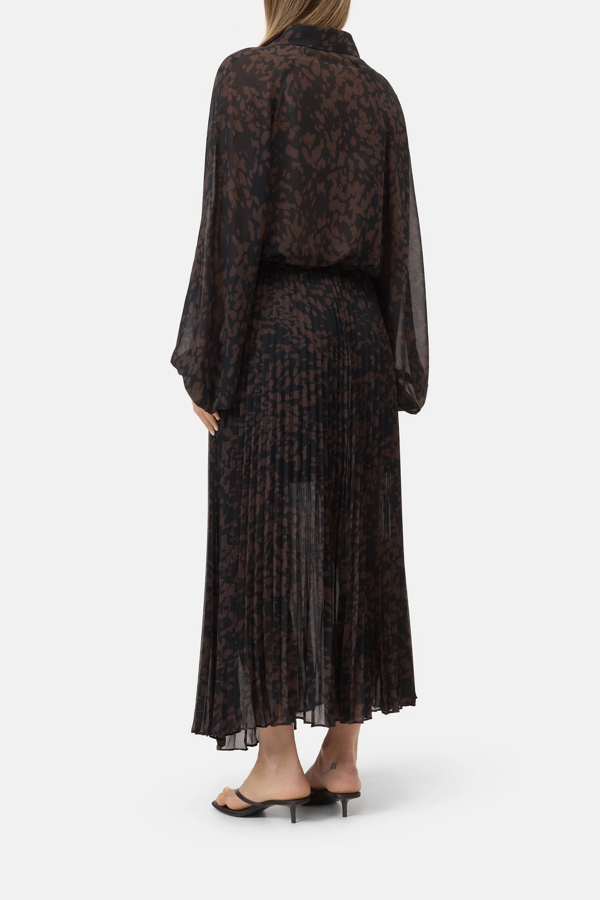 Pleated skirt in a back view paired with black heeled sandals, CLOSED brand, white background.