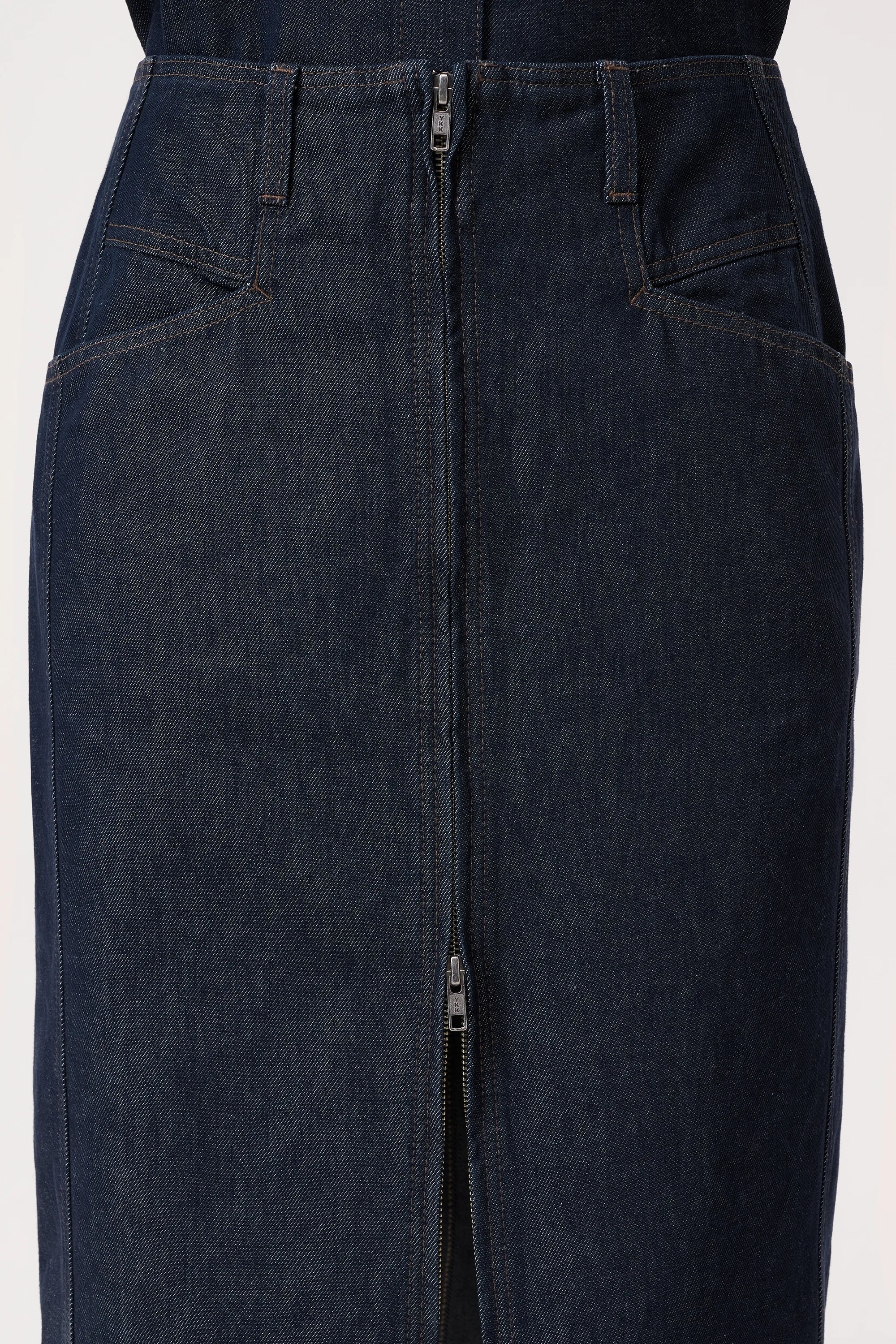 The CLOSED Zip Skirt is crafted from dark blue Italian denim and features an X-pocket design, a bold front zipper running from waistband to hem, and detailed visible stitching.