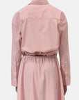 A person is shown from the back wearing the CLOSED Gathered Shirt, a women’s blouse dress with red and white vertical stripes, a cinched waist with gathered detail, buttoned sleeve cuffs, and a relaxed-fit silhouette.