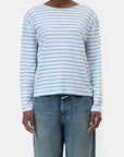 A person wears the CLOSED Basic Long Sleeve Tee in light blue and white stripes with blue jeans, standing against a plain white background.