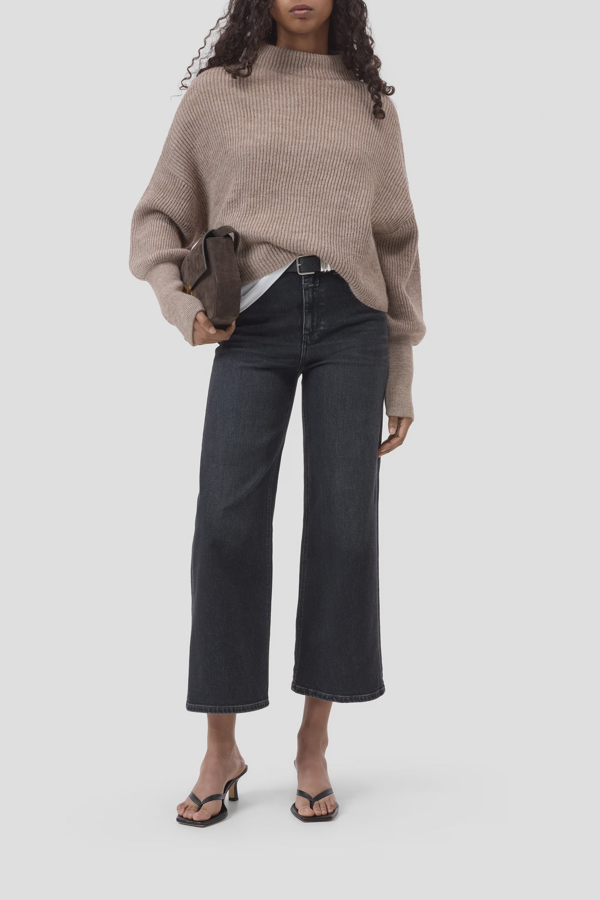 Black wide-leg jeans, funnel neck top, and heeled sandals styled with a brown clutch; modern fall outfit by CLOSED.