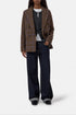 Closed fitted double-breasted blazer in gray, styled with dark jeans and black shoes; classic menswear look.
